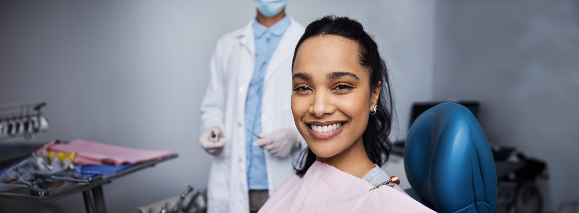 A well-lit reception area with a desk, computer monitor, and potted plant.